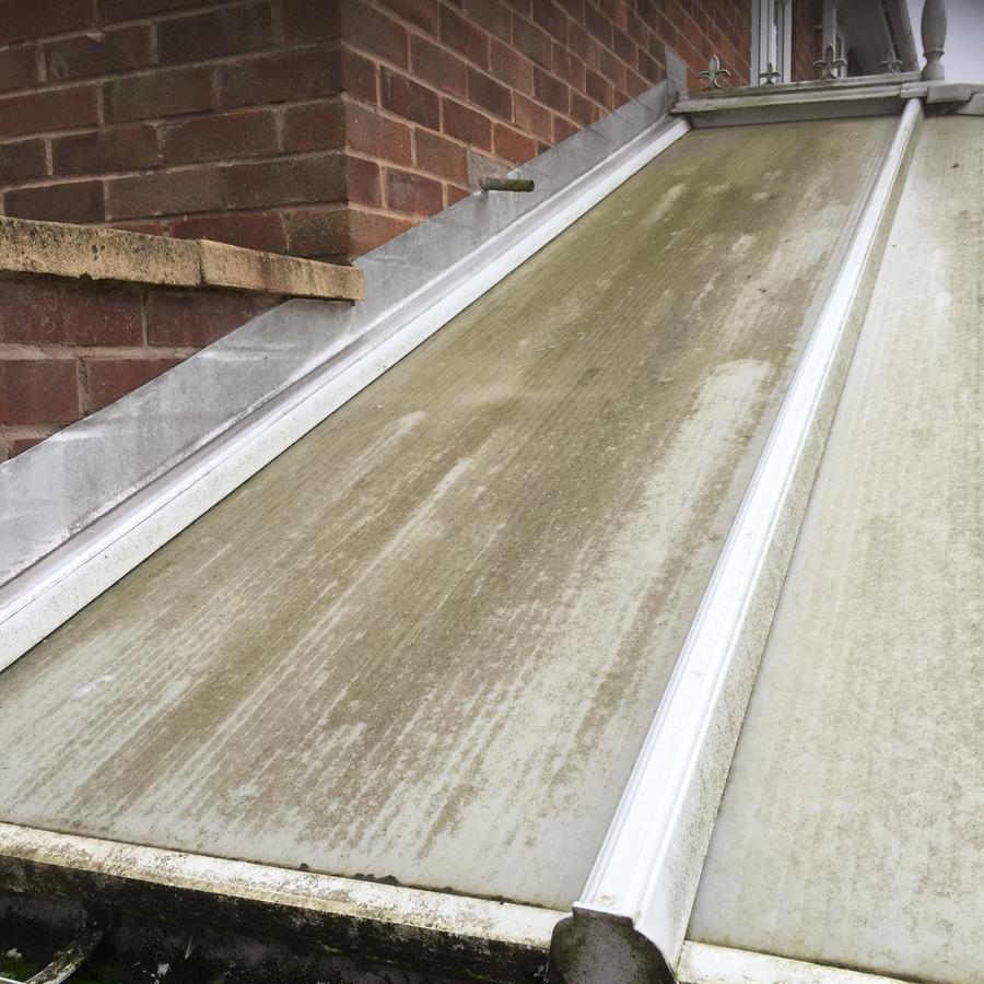 Conservatory roof before cleaning, covered in green algae and dirt